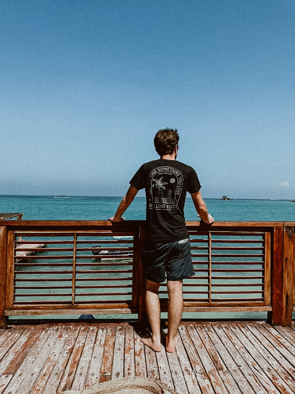 A casual tank top made of 100% cotton fabric with a relaxed fit. The design features a mermaid taking a bath surrounded by waves and palm trees on the back. The front is adorned with the Rolling Vibes logo. Perfect for a beachy, summer look.