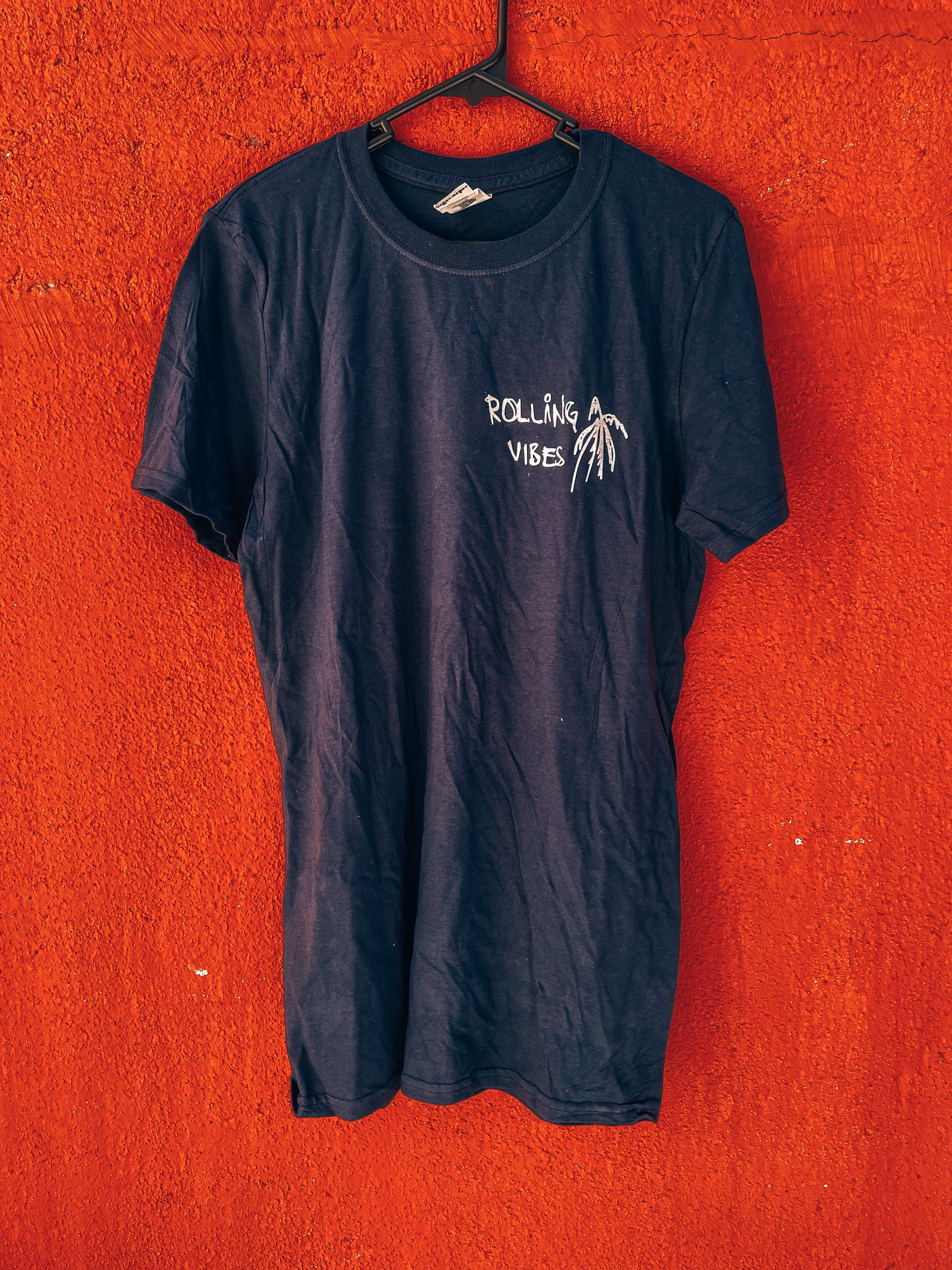 Rolling Vibes Spring T-Shirt in Navy Blue with the Rolling Vibes Logo. 100% cotton, unisex, casual beach vibe clothing perfect for spring. Feel the flow and energy of the season with this shirt. Get yours now and arise in style.